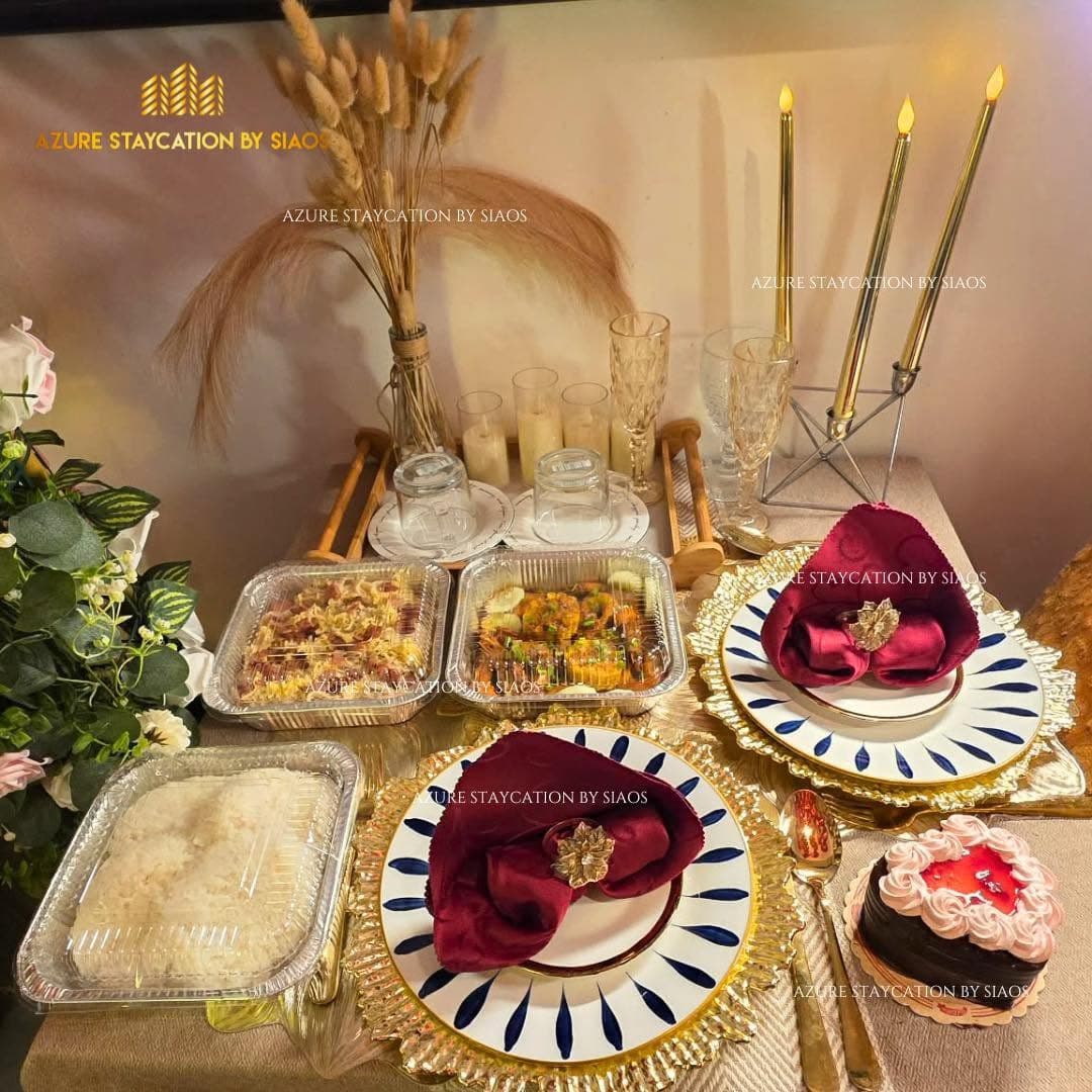 2-pax romantic dinner table setting with candles, wine glasses, and food trays